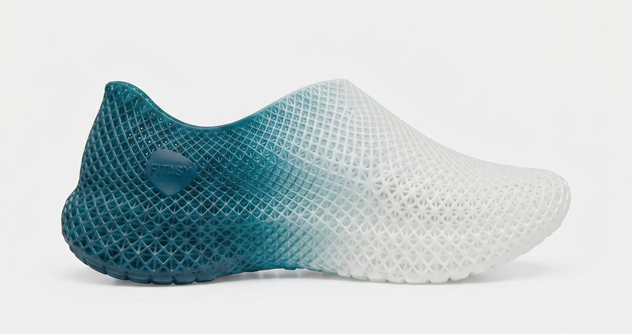 Teal and white shoe with mesh design on a light gray background