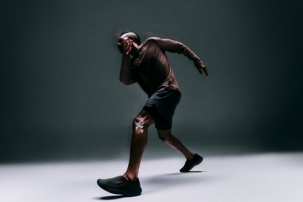 Person in athletic wear running on a dark background