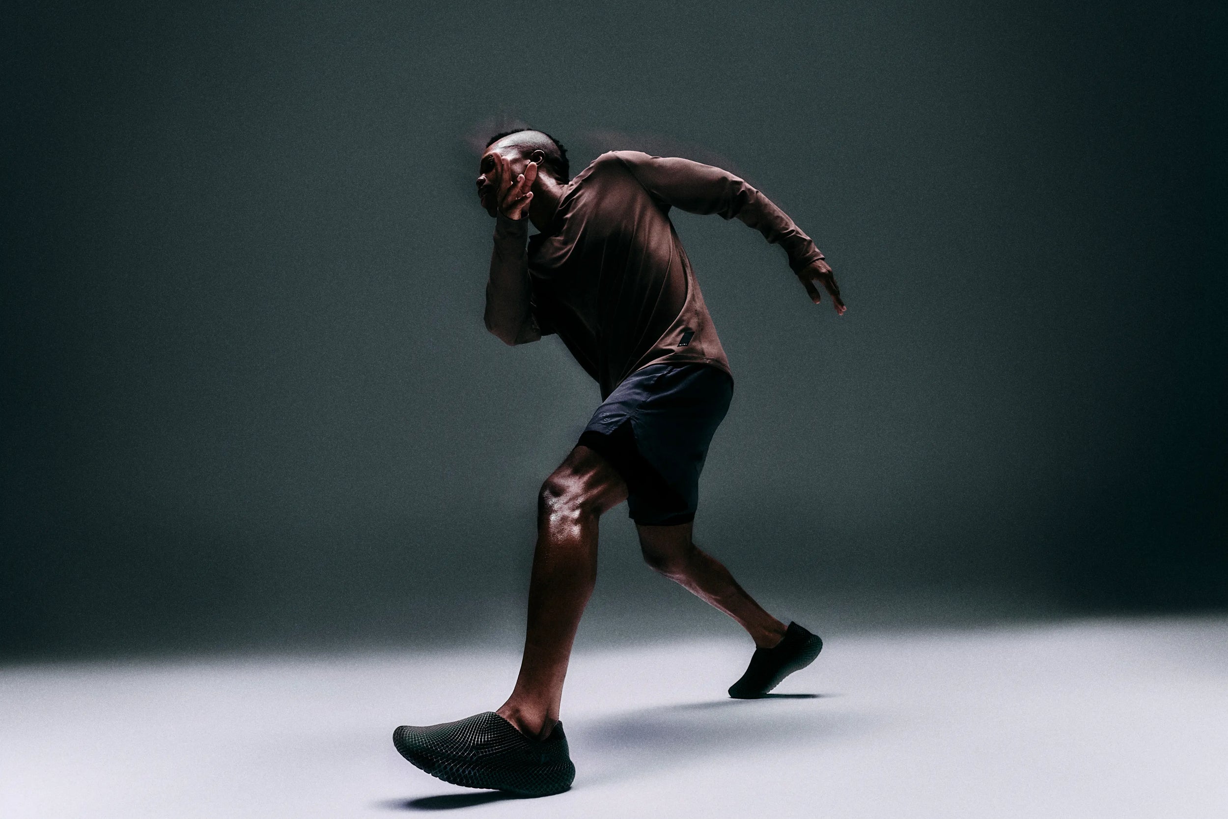 Person in athletic wear running on a dark background