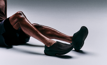 Person wearing black slip-on shoes on a neutral background